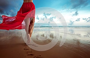 Woman walks towards the ocean