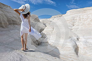 Woman walks on the volcanic rock formations of Sarakiniko, Milos island, Greece