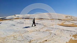 Woman walks in white desert in Egypt