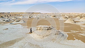 Woman walks in white desert in Egypt