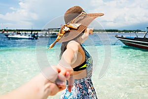 Woman wanting man to follow in honeymoon to beach