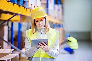 Woman warehouse worker with tablet.