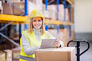 Woman warehouse worker with tablet.