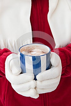 Woman in warm gloves holding cup of hot chocolate