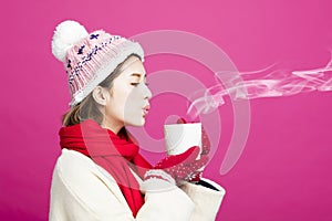 Woman in warm sweater drinking a cup of tea