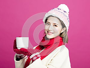 Woman in warm sweater drinking a cup of tea