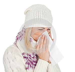 Woman in warm winter clothing sneezing from cold