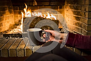 Woman is warming in a fireplace