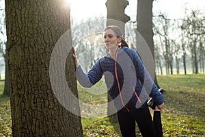 Woman Warming Up For Morning Exercise With Stretches In Winter Park