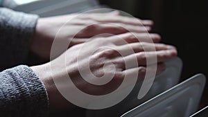 Woman warms hands from electric heater oil radiator indoors. Close-up shot. Cold winter, economic crisis concept