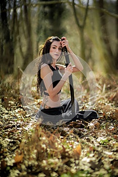 Woman Warrior Holding a Katana Sword, in Mystic Forest