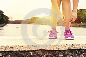 The woman was bent down to tie her shoe for Exercise.