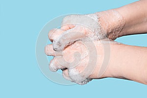 A woman washes and disinfects her hands with soap.
