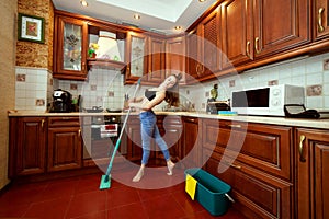 Woman washes the floor with a mop.