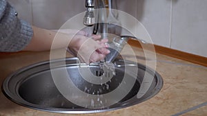 Woman Washes Hands under a Strong Stream of Running Water, Turns off Tap. Splash