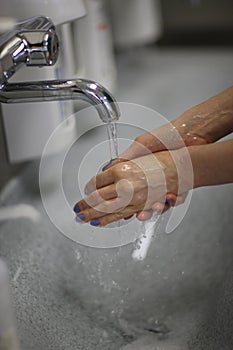 Woman washes her hands