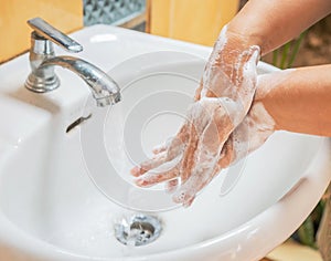 Woman washing back hand rubbing with soap for corona virus prevention avoid infections spread of germs and bacteria