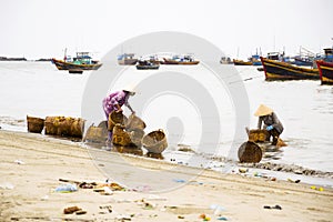 Woman washing baskets on fish sauce production, Mui Ne, Vietnam