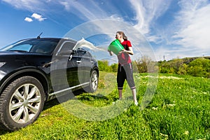 Woman Washing Car with Bucket of Water in Field