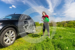 Woman Washing Car with Bucket of Water in Field