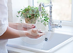 Woman washing dish in sink