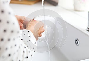 Woman washing dish in sink