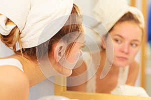 Woman washing face in bathroom. Hygiene