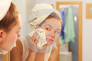 Woman washing face in bathroom. Hygiene