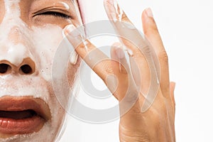 A woman is washing face and foam into the eyes