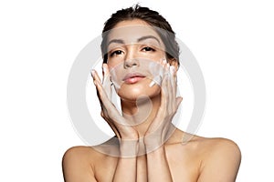 Woman washing  face skin with soap foam