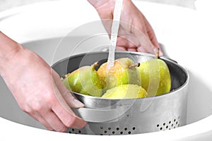 Woman washing fresh ripe in kitchen sink, closeup