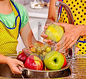 Woman washing fruit at kitchen. photo