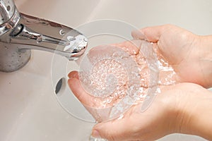 Woman washing hand under running