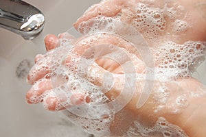 Woman washing hand under running photo