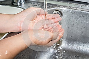 Woman washing hand under running