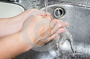 Woman washing hand under running