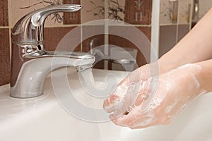 Woman washing hand under running