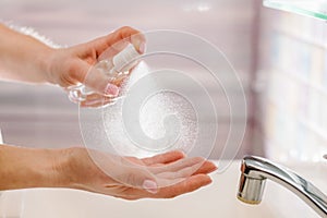 Woman washing hands with alcohol gel or antibacterial soap sanitizer after using a public restroom. Hygiene concept. Prevent the