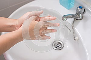 Woman Washing hands with liquid soap Step 3: Interlink your fingers, against Novel coronavirus or Corona Virus Disease Covid-19