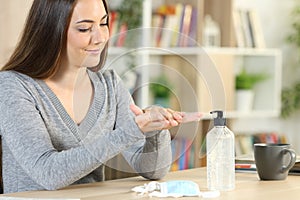 Woman washing hands with sanitizer avoiding covid-19 at home photo
