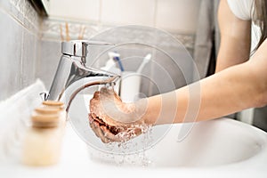 Woman washing hands with soap and water in clean bathroom.Decontamination protocol,hand hygiene routine.Cleaning hands regularly.
