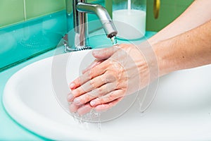 Woman washing hands under the water tap. Hygiene concept