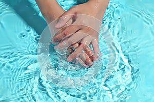Woman washing hands in water to clear respiratory bacteria and viruses