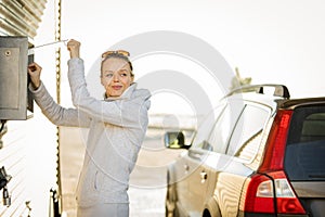 Woman washing her car in a manual carwash