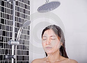 Woman is washing her hair and face by rain shower