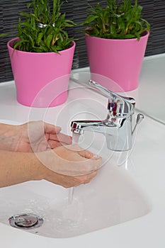 Woman washing her hands under a waterjet Coronavirus pandemic prevention wash hand warm water frequently