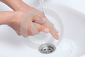 Woman washing her hands under a waterjet photo