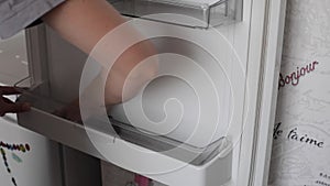 Woman is washing inside fridge at home