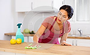 Woman washing kitchen table during cleanup
