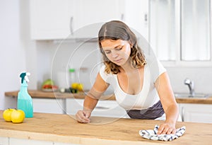 Woman washing kitchen table during cleanup